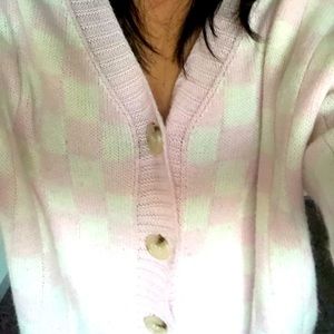 A lowcut pink checkered sweater with cream colored buttons